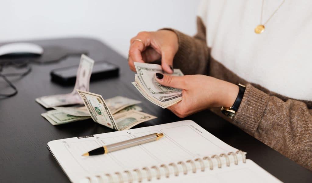 A woman sitting at a table counting money