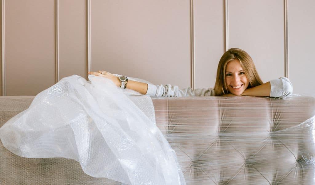 Woman smiling behind the headboard wrapped in bubble wrap