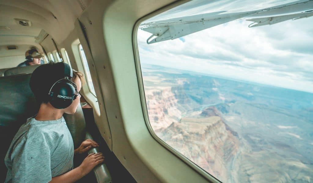 A young boy looks out an airplane window to see Arizona for the first time