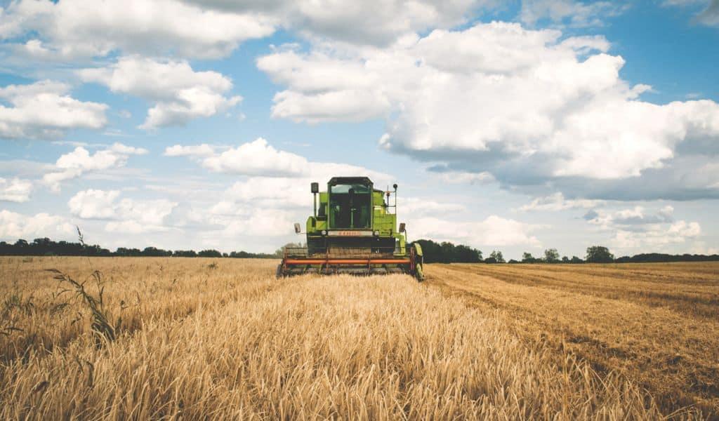 Green tractor plowing fields.