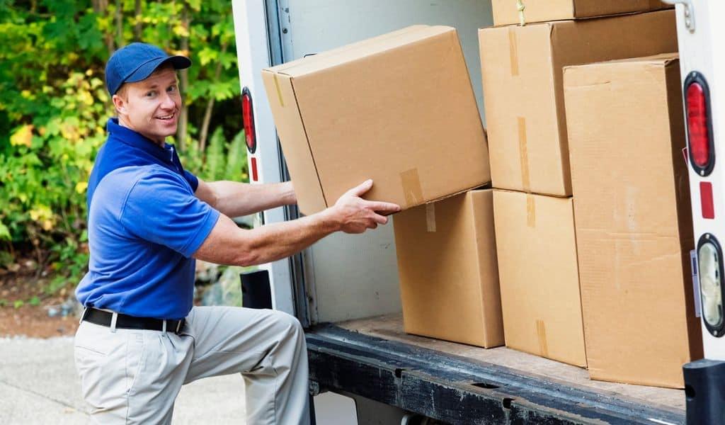 Professional moving company man taking box out of van