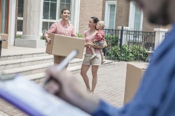 Family with moving boxes and a professional mover