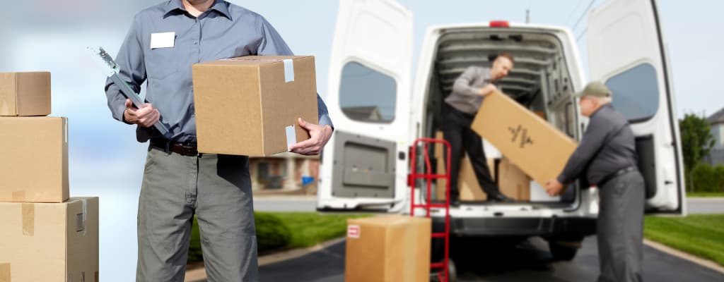 Professional movers helping pack things in truck