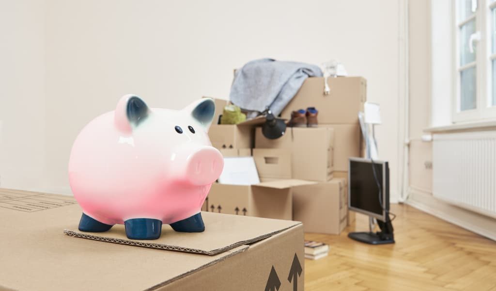 Piggy bank savings on top of moving boxes