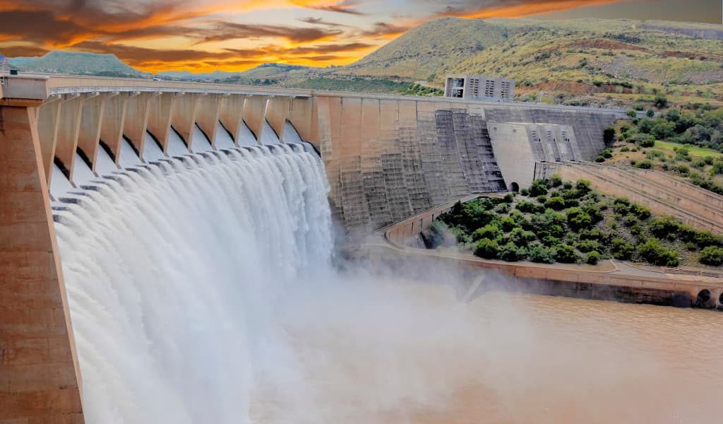 The great Hoover Dam at sunset showing the water flowing through the spillways