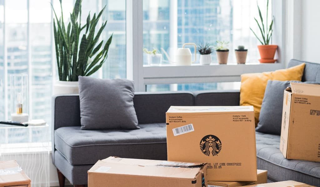 Cardboard boxes packed and placed in the living room waiting to be moved