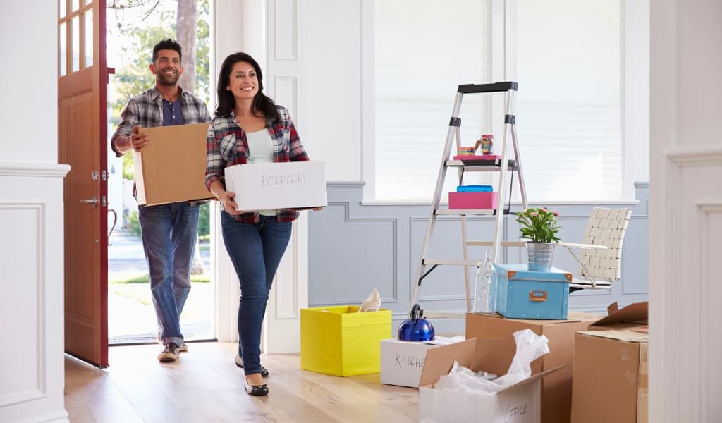 Couple holding boxes as they move into their New Home in Oklahoma