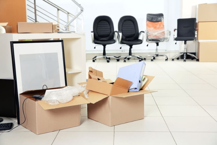 Binders and frames packed into boxes in an office.