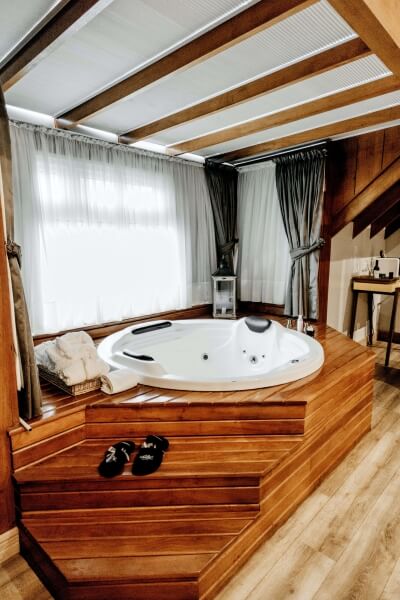 White wooden hot tub atop a tiered wooden spa