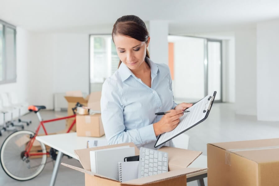 Woman checking over packed business boxes