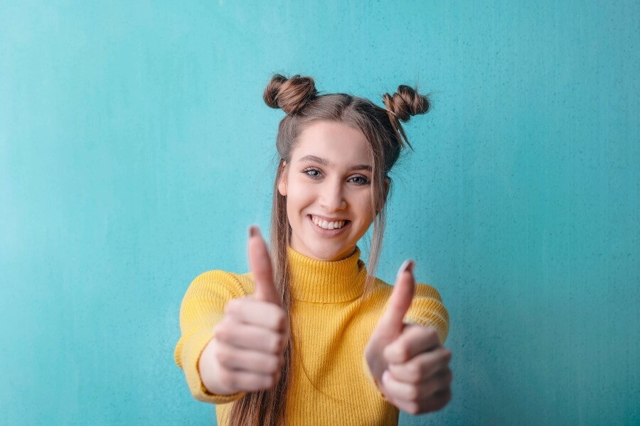 Woman smiling holding thumbs up.