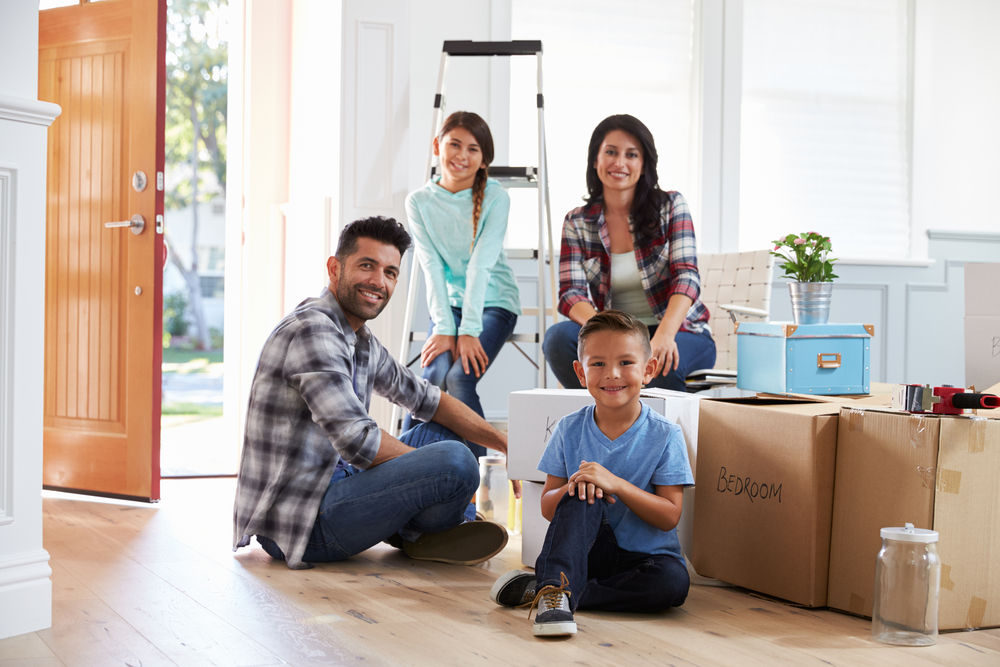 Happy family surrounded by moving boxes